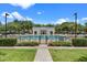 Beautiful community pool and clubhouse area enclosed by a wrought iron fence, lush landscaping and plenty of chairs at 1859 Britlyn Aly, Orlando, FL 32814