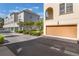 Garage view of a tan stucco townhome surrounded by beautiful green landscaping at 1859 Britlyn Aly, Orlando, FL 32814