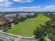 Extensive green space in a community with walking trails, mature trees, and residential buildings in the background at 1859 Britlyn Aly, Orlando, FL 32814