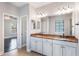 Bathroom featuring a double vanity with stone countertop, undermount sinks, and decorative lighting at 1859 Britlyn Aly, Orlando, FL 32814