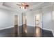 Spacious main bedroom with dark hardwood floors, tray ceiling, ceiling fan, and ensuite bathroom and walk-in closet at 1859 Britlyn Aly, Orlando, FL 32814