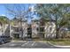 Inviting condo with a tan exterior, mature trees, and convenient parking at 1948 Lake Atriums Cir # 129, Orlando, FL 32839