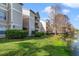 Exterior view of apartment buildings with grass and trees, near a lake at 1948 Lake Atriums Cir # 129, Orlando, FL 32839