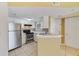 A bright kitchen featuring stainless steel appliances and ample white cabinets at 1948 Lake Atriums Cir # 129, Orlando, FL 32839