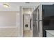 Practical laundry area with a stacked washer and dryer next to stainless refrigerator at 1948 Lake Atriums Cir # 129, Orlando, FL 32839