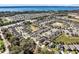 This aerial view features a well-planned residential community near a picturesque lake at 2491 Bracknell Forest Trl, Tavares, FL 32778