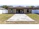 View of the backyard with a patio and chairs, set on a grass yard surrounded by a white fence at 2491 Bracknell Forest Trl, Tavares, FL 32778