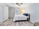 Bright bedroom with wood-look floors, ceiling fan, and a window at 2491 Bracknell Forest Trl, Tavares, FL 32778