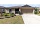 Charming single-story home featuring a two-car garage, well-kept lawn, and manicured landscaping at 2491 Bracknell Forest Trl, Tavares, FL 32778