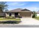 Inviting single-story home with a well-manicured lawn and a two-car garage at 2491 Bracknell Forest Trl, Tavares, FL 32778