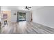 Open-concept living room with new floors, sliding glass doors, and lots of natural light at 2491 Bracknell Forest Trl, Tavares, FL 32778