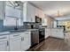 Well-lit kitchen featuring stainless steel appliances, white cabinetry, granite counters and a dining area at 2812 Mulford Ave, Winter Park, FL 32789