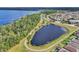 Beautiful aerial view of a lake surrounded by lush greenery and walking trails at 3128 Dark Sky Dr, Harmony, FL 34773