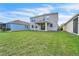 A spacious backyard features lush green grass and a covered patio perfect for outdoor living at 3128 Dark Sky Dr, Harmony, FL 34773