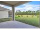 Scenic backyard view of a golf course, a lake, and wooded area from a covered lanai at 3128 Dark Sky Dr, Harmony, FL 34773