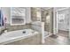 Bright bathroom featuring a soaking tub, a separate glass-enclosed shower and window at 3128 Dark Sky Dr, Harmony, FL 34773