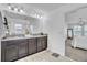 Modern bathroom with a granite countertop double vanity and dark wood cabinets and mirror at 3128 Dark Sky Dr, Harmony, FL 34773