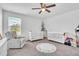 Cozy Bedroom featuring two cribs, a ceiling fan, a comfortable chair, and a soft rug at 3128 Dark Sky Dr, Harmony, FL 34773