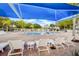 Inviting community pool with lounge chairs and umbrellas under a blue sky at 3128 Dark Sky Dr, Harmony, FL 34773