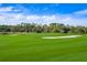 Lush green golf course with sand traps under a partly cloudy sky at 3128 Dark Sky Dr, Harmony, FL 34773