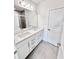 Bathroom featuring double sinks, quartz countertops, modern fixtures and a walk-in shower at 3219 Cup Dr, Lakeland, FL 33803