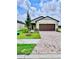 Charming single-Gathering home featuring a brick driveway, two-car garage, and well-manicured lawn at 3219 Cup Dr, Lakeland, FL 33803