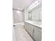Bright bathroom featuring gray cabinets, double sinks, a large mirror, and a tiled shower-tub combination at 3352 Cup Dr, Lakeland, FL 33803