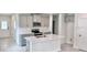 Kitchen with an island featuring gray cabinets, quartz countertops, and stainless steel appliances at 3352 Cup Dr, Lakeland, FL 33803
