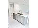 Kitchen island with a stainless steel sink, gray cabinetry, and quartz countertops at 3352 Cup Dr, Lakeland, FL 33803