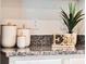 Granite countertop in kitchen features decorative canisters, a potted plant, and an 'EAT' decorative statue at 3629 Marlberry Way, Sanford, FL 32773
