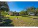 Spacious backyard with a shed, mature trees, and a screened-in porch at 401 Cart Ct, Kissimmee, FL 34759