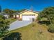 Charming yellow home with a well-maintained lawn and a long driveway at 401 Cart Ct, Kissimmee, FL 34759