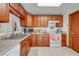Practical kitchen with wood cabinets, white appliances, and generous counter space at 401 Cart Ct, Kissimmee, FL 34759