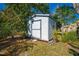 Backyard shed for extra storage, surrounded by mature landscaping and trees at 401 Cart Ct, Kissimmee, FL 34759