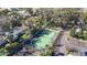 Aerial view of a well-maintained tennis court, perfect for recreational enjoyment surrounded by mature trees at 4117 Fairview Vista Pt # 206, Orlando, FL 32804