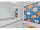 Colorful bathroom with granite vanity top, white cabinets, and a shower with sports-themed curtain at 4484 Lions Gate Ave, Clermont, FL 34711