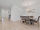 Open-concept dining room featuring wood floors, a modern chandelier, and access to the staircase at 4484 Lions Gate Ave, Clermont, FL 34711
