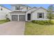 Charming two-story home with a two-car garage, brick driveway, and well-kept lawn at 4484 Lions Gate Ave, Clermont, FL 34711