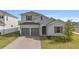 Charming two-story home with gray shutters, a brick driveway, and manicured landscaping at 4484 Lions Gate Ave, Clermont, FL 34711