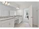 Bright main bathroom with dual granite sinks, white cabinets, and well-lit vanity at 4484 Lions Gate Ave, Clermont, FL 34711