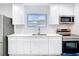 Bright kitchen with stainless steel appliances, white cabinets and a window over the sink at 4502 Florence St, Apopka, FL 32712