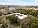 Aerial view of a multi-story building with red tile roof surrounded by trees and city skyline at 535 N Interlachen Ave # 106, Winter Park, FL 32789