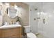 Well-lit bathroom featuring a glass shower door, patterned wallpaper and a round mirror at 535 N Interlachen Ave # 106, Winter Park, FL 32789