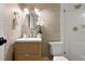 Well-lit bathroom featuring a glass shower door, patterned wallpaper and a round mirror at 535 N Interlachen Ave # 106, Winter Park, FL 32789