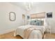 Bright bedroom with wood floors, chandelier, mirror, and a white comforter on the bed at 535 N Interlachen Ave # 106, Winter Park, FL 32789