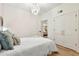 Modern bedroom with white bedding, hard wood floors, closet space and an eye-catching light fixture at 535 N Interlachen Ave # 106, Winter Park, FL 32789