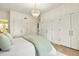 Bright main bedroom featuring hardwood floors, closet space, and a stylish chandelier at 535 N Interlachen Ave # 106, Winter Park, FL 32789