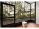 Enclosed patio with black-framed windows overlooking lush greenery and mature trees at 535 N Interlachen Ave # 106, Winter Park, FL 32789