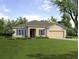 Well maintained single story home with neutral color palette, manicured lawn, and mature trees at 6552 Rhythm Dr, Mascotte, FL 34753