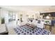 Open-concept living room showcasing a tile floor, white sofas, a blue patterned rug, and a kitchen view at 6552 Rhythm Dr, Mascotte, FL 34753